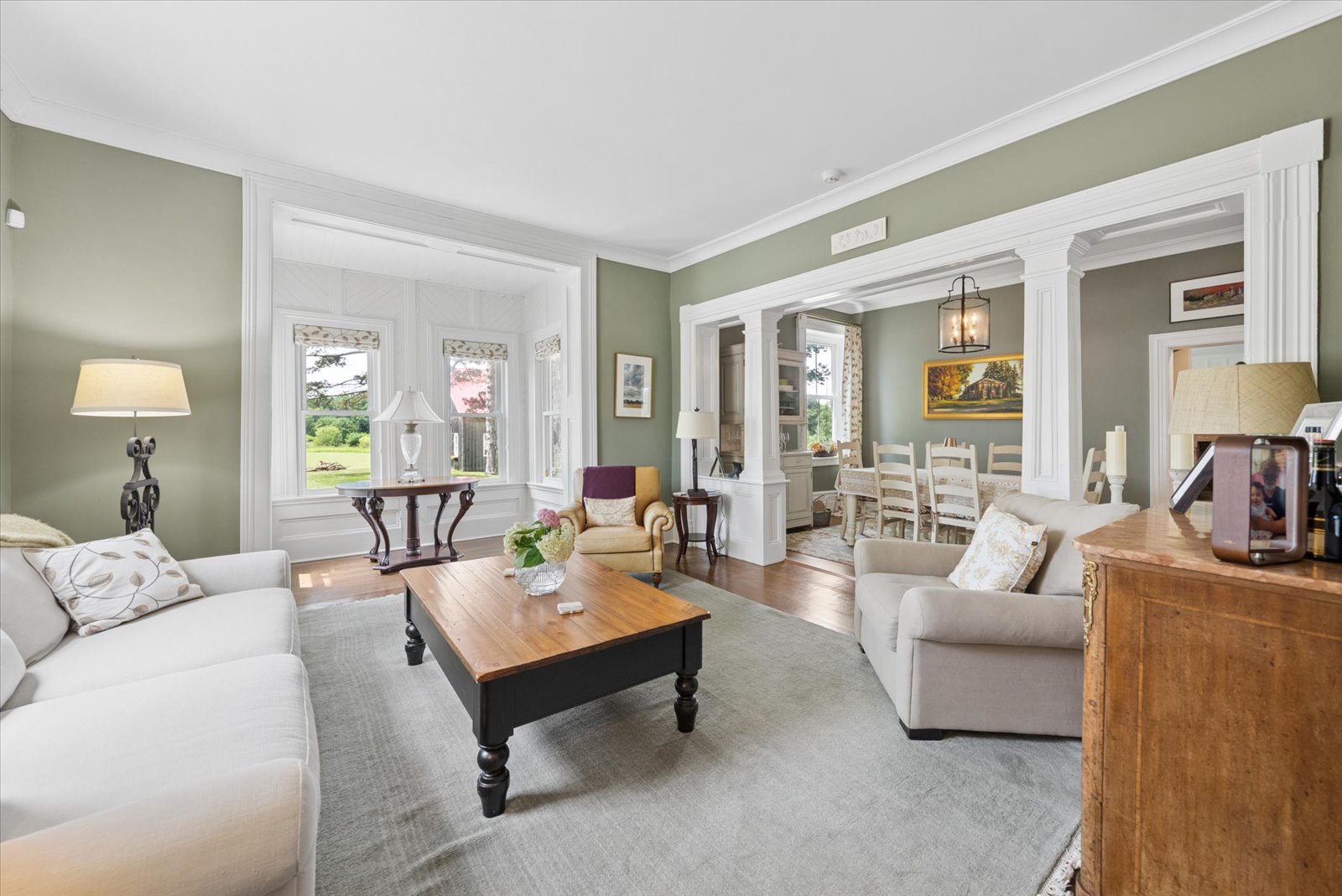 Living room opening onto the dining room through columned archways