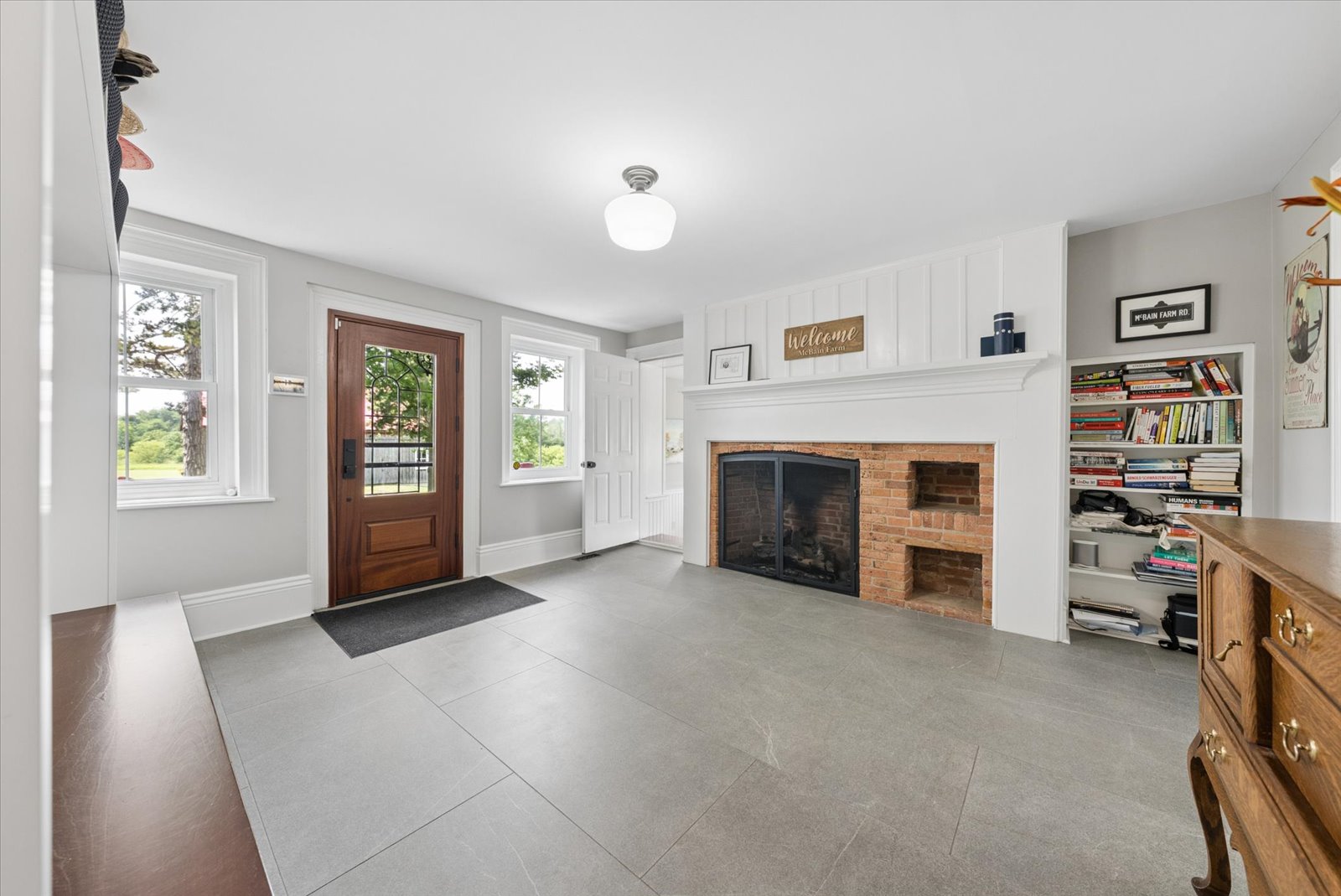 Back entry hall with wood-burning fireplace and built-in shelving